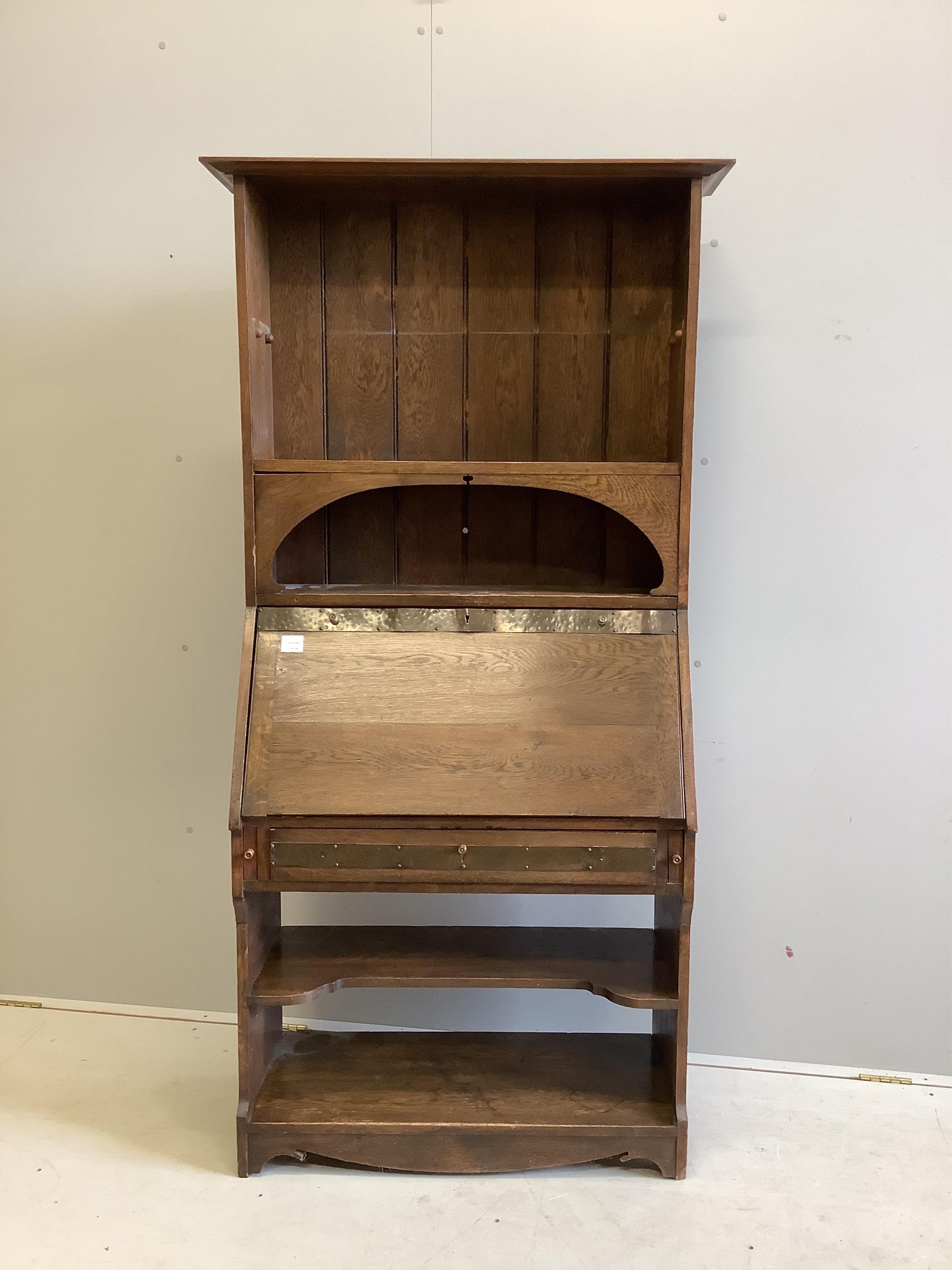 An Arts and Crafts brass mounted oak bureau bookcase, width 84cm, depth 38cm, height 185cm. Condition - fair